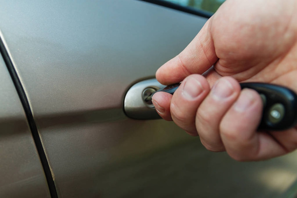 La main de l'homme ouvre la porte de la voiture avec une clé - Photo, image