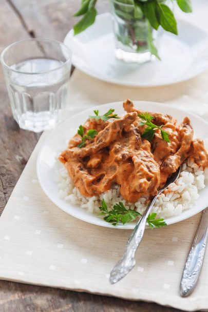 Dish rice with beef stroganoff on a white plate - Photo, Image