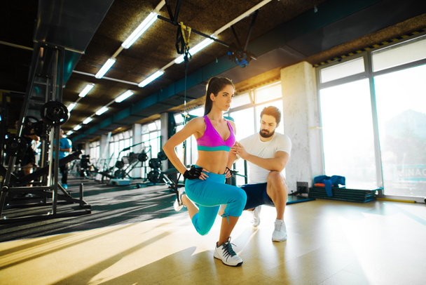 woman with personal trainer in gym - Photo, Image