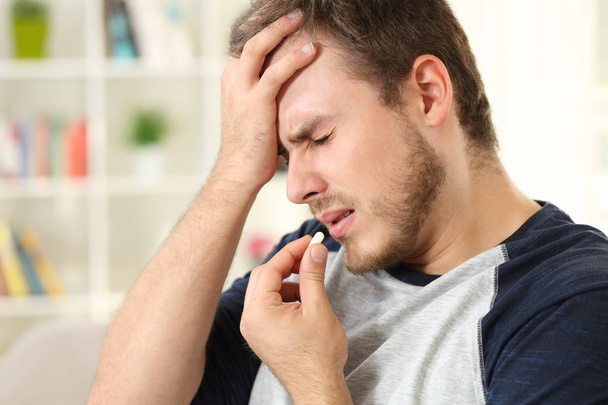 Man suffering headache taking a pill - Foto, Bild