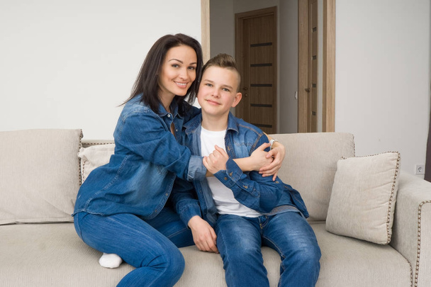 Portrait of mother and her son on sofa at home - Фото, зображення