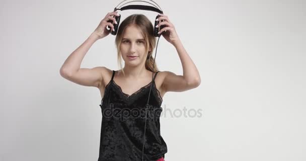 Attractive blond girl in loungewear and headphones - Materiał filmowy, wideo