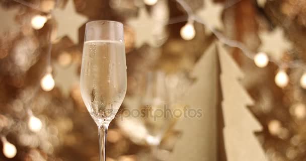 Шампанське виливають у склянку з різдвяні прикраси - Кадри, відео
