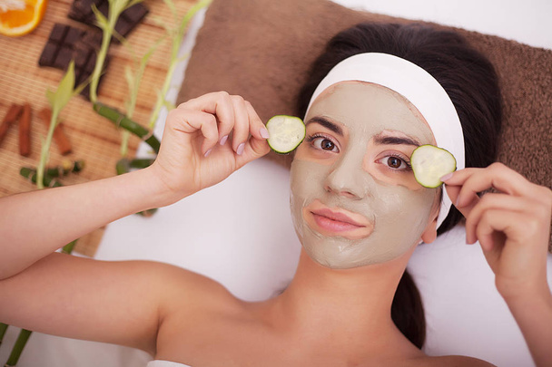 La aplicación de la máscara facial a la cara de la mujer en el salón de belleza
 - Foto, imagen