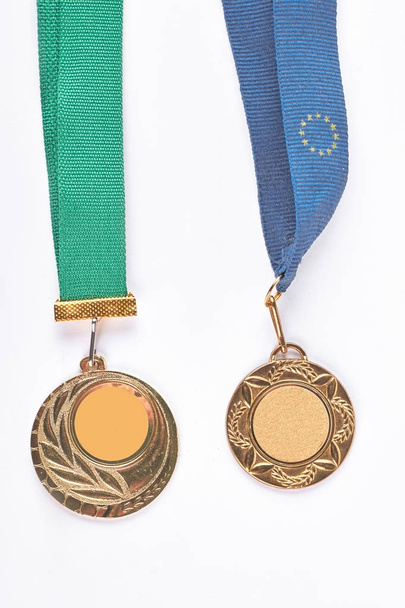 Две золотые медали висят на лентах
. - Фото, изображение
