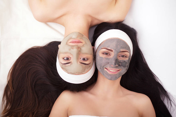 Χρήση του μια μάσκα προσώπου για να το πρόσωπο δύο κοπέλες στο σαλόνι ομορφιάς - Φωτογραφία, εικόνα