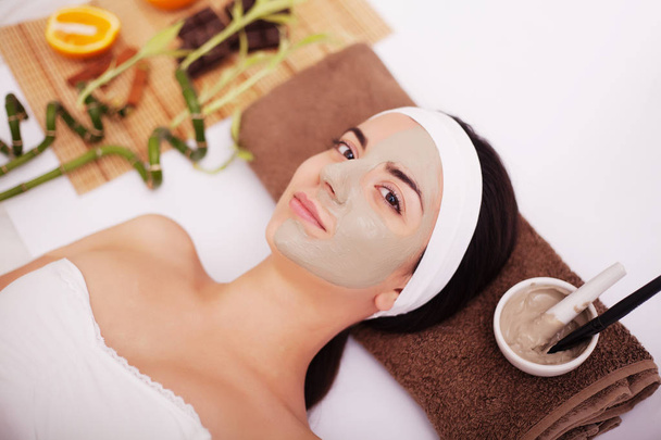 Fiatal nő agyag bőr maszk kezelés az arcán - Fotó, kép
