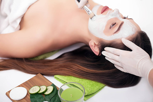 Concept de spa. Jeune femme avec masque facial nutritif dans un salon de beauté, gros plan - Photo, image