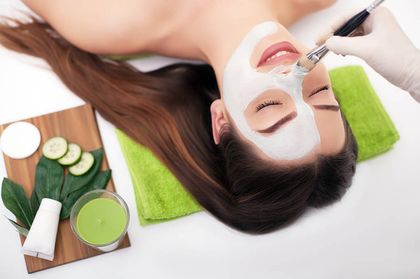 Terapia de spa de mulher jovem que recebe máscara facial no salão de beleza - em casa
 - Foto, Imagem