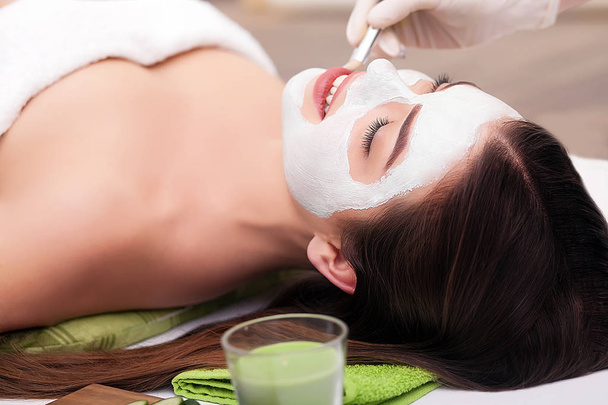 Cosmetico applicare maschera di bellezza del viso per la giovane bella donna al salone spa
 - Foto, immagini