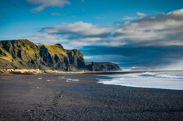 Black Beach and Sea-stacks in Vik Iceland with mountains waves a - Foto, imagen