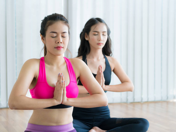 Women practicing yoga pose in fitness gym class - Fotografie, Obrázek