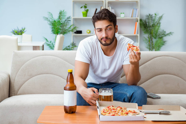 男食べるピザを持っています持ち帰りでホームリラックスした休息 - 写真・画像