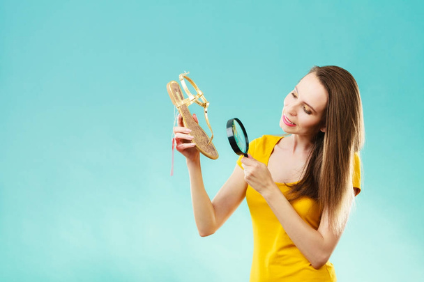 woman choosing shoes searching through magnifying glass - Фото, изображение
