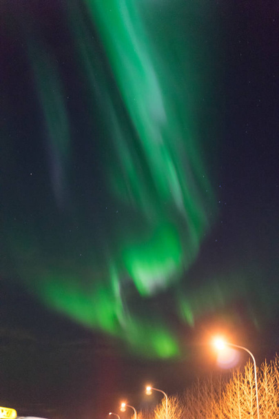 Northern lights Aurora Borealis above street in Iceland - Photo, Image