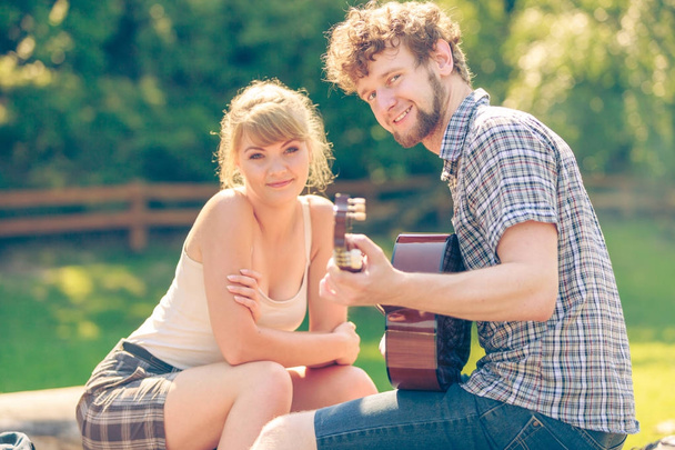 Young couple camping playing guitar outdoor - Photo, image