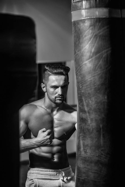 Muscular man with punching bag - Valokuva, kuva