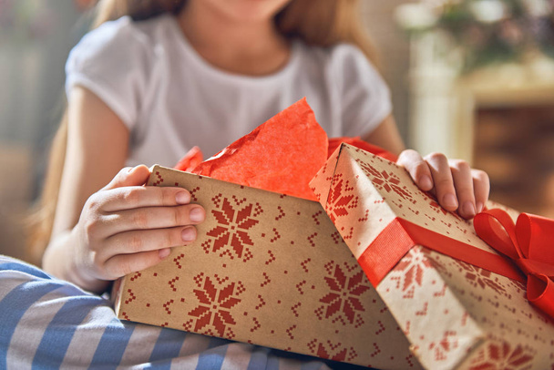 child opening gift - Фото, изображение