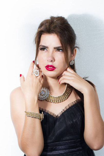 Portrait of a girl with bright make-up and jewelery made of costume jewelery - Zdjęcie, obraz