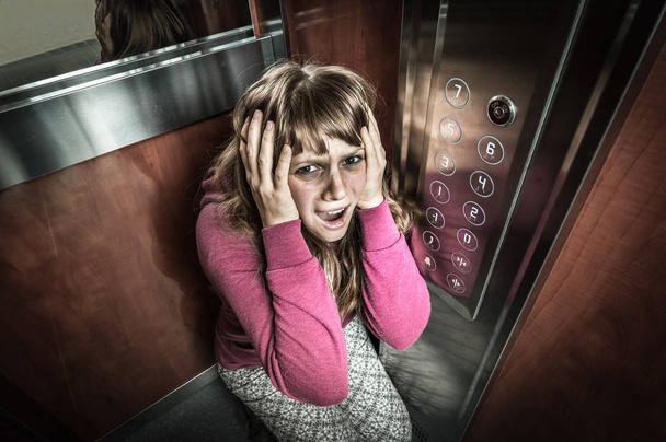 Shocked woman with claustrophobia in the moving elevator - Zdjęcie, obraz
