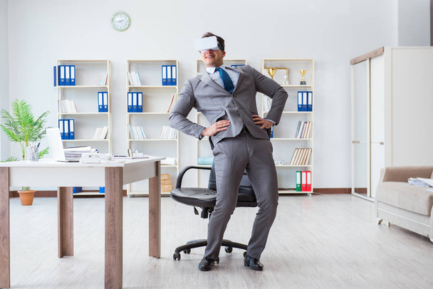 Businessman exercising in office wearing VR glasses - Photo, Image