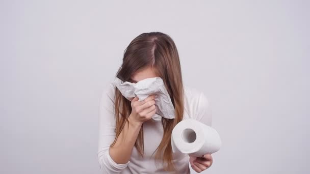 Mujer estornudando en un tejido sobre el fondo blanco
 - Imágenes, Vídeo