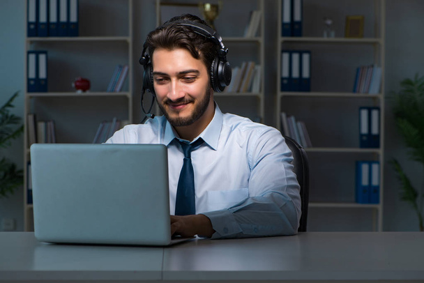 Young man in call center concept working late overtime in office - Photo, image