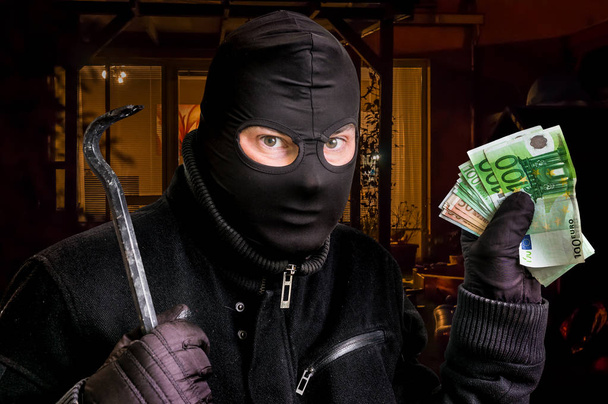 Zamaskowany złodziej w mieście balaclava za skradzione pieniądze - Zdjęcie, obraz