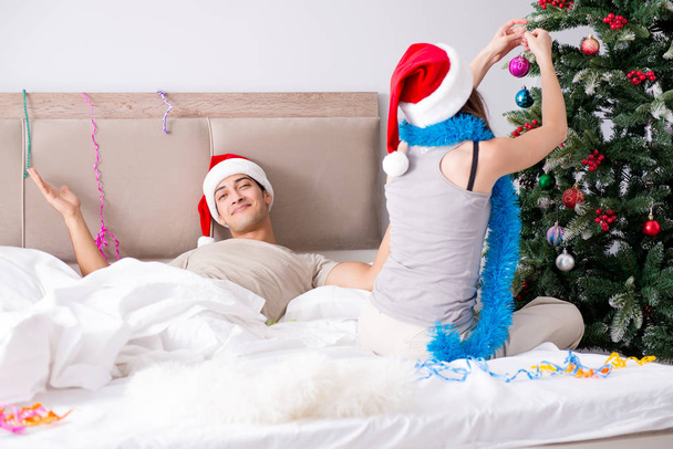 Young happy family celebrating christmas in bed - Фото, зображення