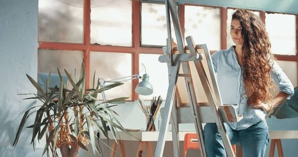 Cute red-haired girl paints in her studio - Photo, Image