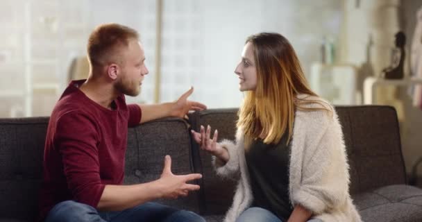 Young couple having harsh controversies on a couch - Záběry, video