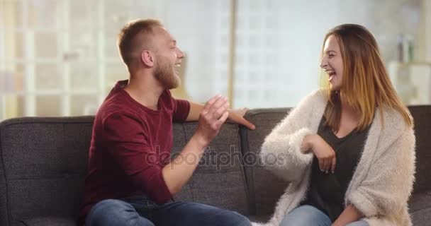Young couple having fun on a couch - Záběry, video
