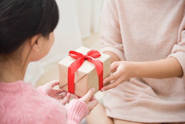 Asian girl receiving a brown gift box. - Photo, image