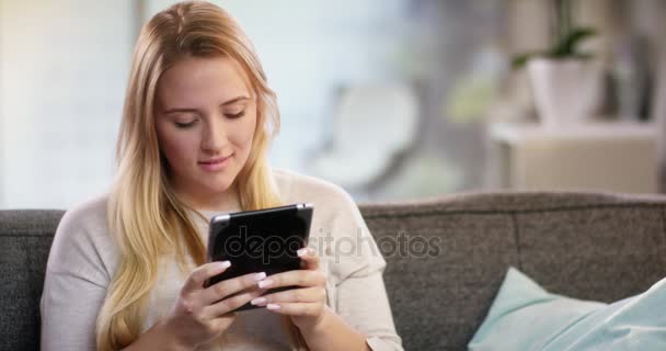 Young woman doing something on a tablet - Video