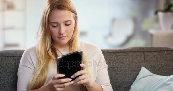Young woman texting something on a tablet - Video