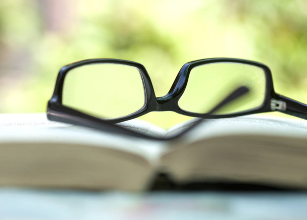 Közelkép a szemüveg feküdt egy nyitott könyv  - Fotó, kép