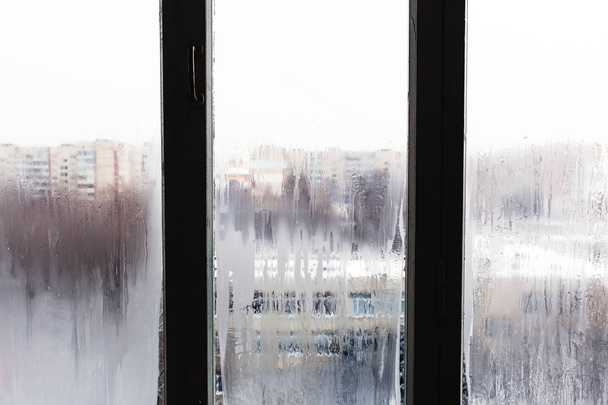 Ijs op berijpte venster, straatmening vanuit venster - Foto, afbeelding