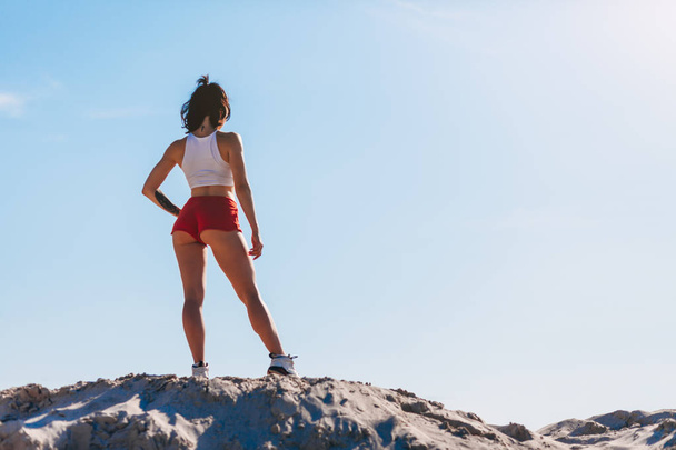 fit woman standing on rocky hill - Photo, image