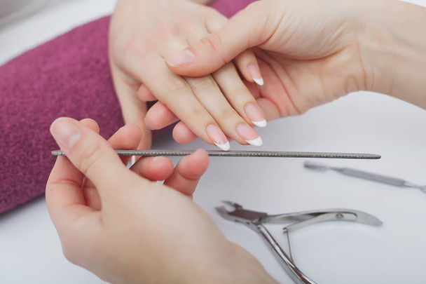 Woman hands in a nail salon receiving a manicure procedure. SPA  - Fotoğraf, Görsel
