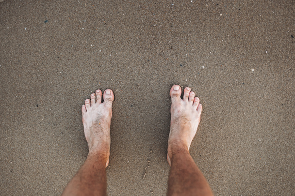 Les pieds de l'homme sur le fond de sable jaune sur la plage
 - Photo, image