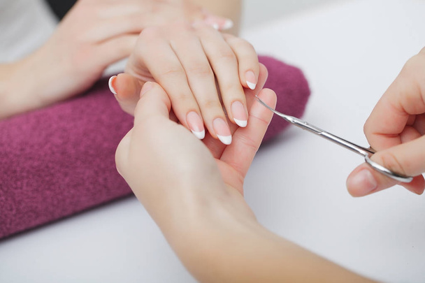 Woman hands in a nail salon receiving a manicure procedure. SPA  - Photo, Image