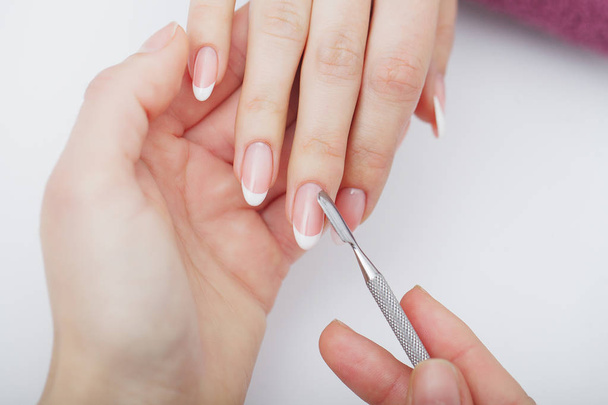 Woman hands in a nail salon receiving a manicure procedure. SPA  - Foto, afbeelding