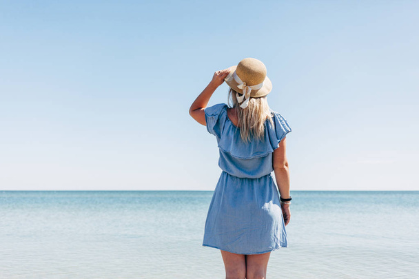 Mujer con sombrero de paja en el mar
 - Foto, imagen