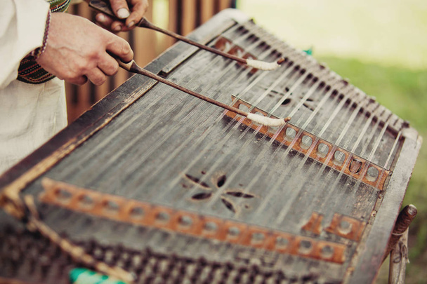 ウクライナ伝統音楽文字列楽器ツィンバロム。伝統的な身に着けている男の服民族のウクライナ音楽を再生。表示を閉じる. - 写真・画像