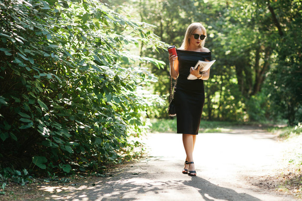 Frau mit Zeitschriften und Kaffee im Park - Foto, Bild