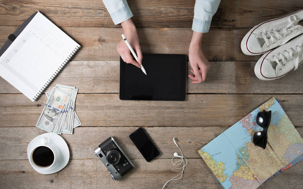 Женщина с планшетным ПК на рабочем столе с картой мира и co
 - Фото, изображение