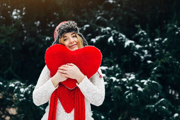 žena držící srdce tvarovaný polštář - Fotografie, Obrázek