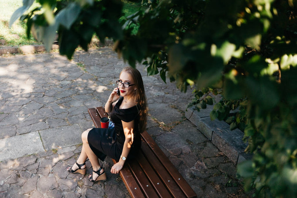 γυναίκα κάθεται στον πάγκο στο πάρκο - Φωτογραφία, εικόνα