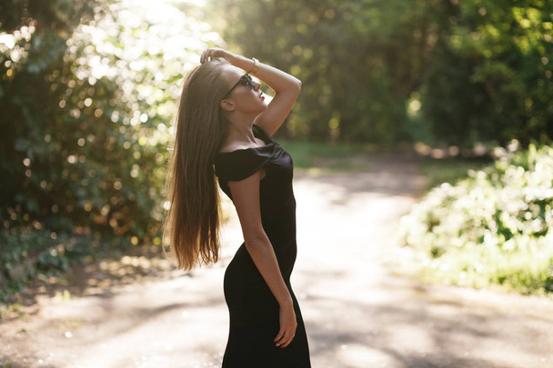 woman in black dress posing in park - Foto, Imagem