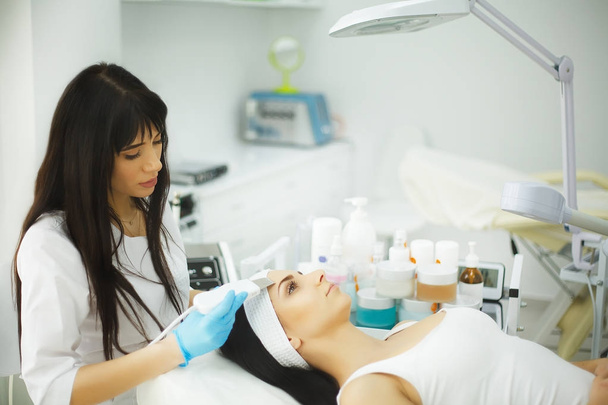 Rejuvenating facial treatment. Model getting lifting therapy massage in a beauty SPA salon. Exfoliation, Rejuvenation And Hydratation. Model and Doctor. Cosmetology. - Photo, Image